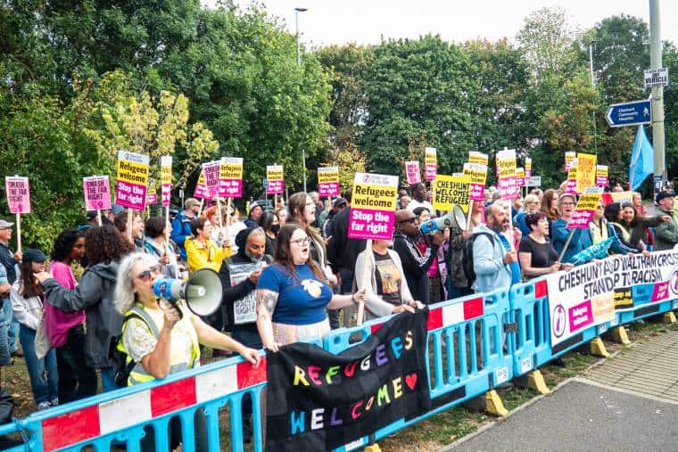 Large crowd of several dozen anti-racists with bright placards and megaphones